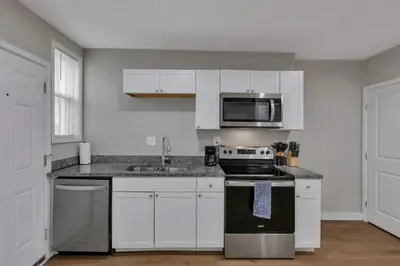 a kitchen with white cabinets and a stove and microwave at Modern Townhouse in Historic Building Walk to Downtown in Columbus