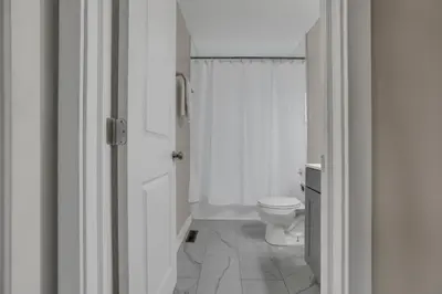 a white bathroom with a toilet and a shower at Modern Townhouse in Historic Building Walk to Downtown in Columbus