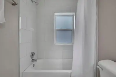a white bathroom with a shower and a window at Modern Townhouse in Historic Building Walk to Downtown in Columbus