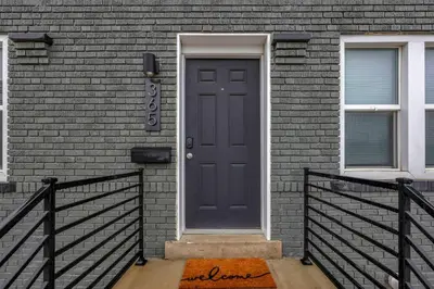 a black door on a brick house with a porch at Modern Townhouse in Historic Building Walk to Downtown in Columbus