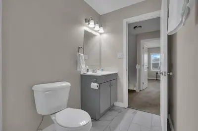 a bathroom with a toilet and a sink and a mirror at Perfect Short Stay in Historic Columbus Walkable Modern & Easy in Columbus