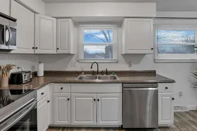 a kitchen with white cabinets and a sink at Modern 4BR Retreat Fenced Yard Near Easton in Columbus