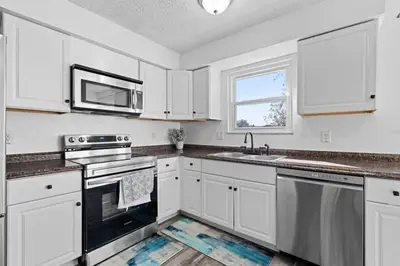 a kitchen with white cabinets and a sink and a microwave at Modern 4BR Retreat Fenced Yard Near Easton in Columbus