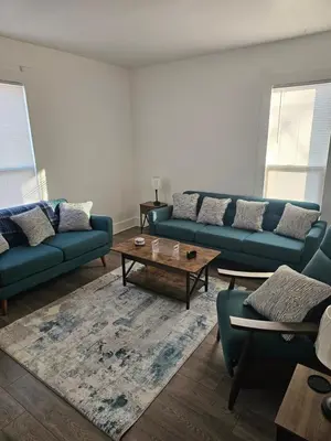 a living room with blue couches and a coffee table at Furnished 2-bedroom Downtown Anderson IN in Anderson