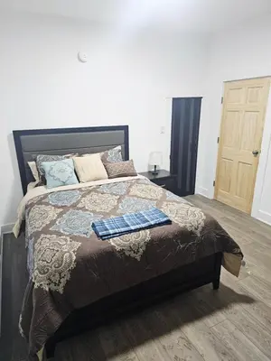 a bedroom with a large bed with a wooden door at Furnished 2-bedroom Downtown Anderson IN in Anderson
