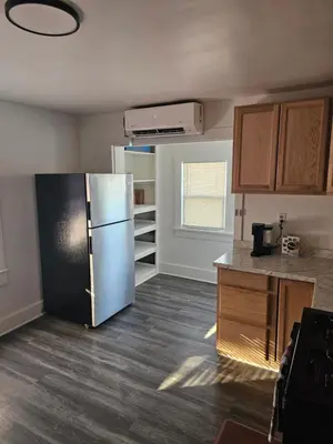 a kitchen with a refrigerator in the middle of a room at Furnished 2-bedroom Downtown Anderson IN in Anderson
