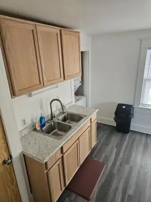 a kitchen with a sink and wooden cabinets at Furnished 2-bedroom Downtown Anderson IN in Anderson