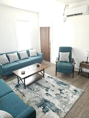 a living room with two blue couches and a coffee table at Furnished 2-bedroom Downtown Anderson IN in Anderson
