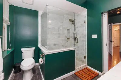 a green bathroom with a toilet and a shower at Velvet Haus Downtown 3rd Floor Deck Backyard in Cincinnati