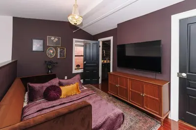 a living room with a couch and a flat screen tv at Velvet Haus Downtown 3rd Floor Deck Backyard in Cincinnati
