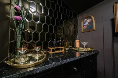 a bar with glasses and bottles of wine on a counter at Velvet Haus Downtown 3rd Floor Deck Backyard in Cincinnati