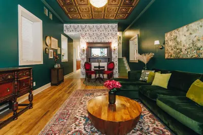a living room with a green couch and a table at Velvet Haus Downtown 3rd Floor Deck Backyard in Cincinnati