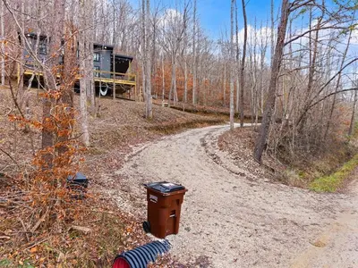 a trash can on a dirt road in the woods at Romantic Secluded Hot Tub, Stargazing, Mt View in Stanton