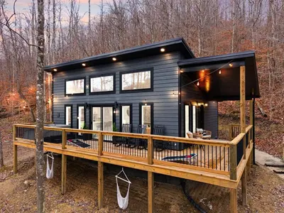 a tiny house in the woods with a large deck at Romantic Secluded Hot Tub, Stargazing, Mt View in Stanton