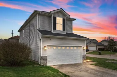 a house with a garage with a sunset at Spacious King Suite, Game Room, Patio, Firepit in Lexington