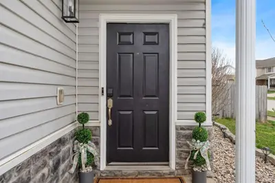 a black door on a house with two potted plants at Spacious King Suite, Game Room, Patio, Firepit in Lexington
