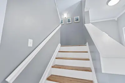 a staircase in a house with white walls and wooden floors at Spacious King Suite, Game Room, Patio, Firepit in Lexington