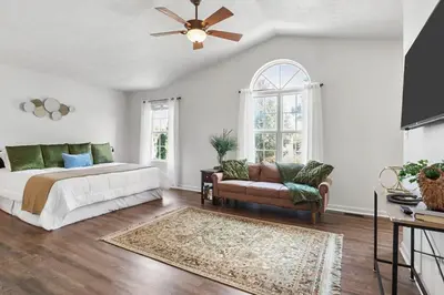 a bedroom with a bed and a couch and a ceiling fan at Spacious King Suite, Horses, Fire Pit, Garage in Lexington
