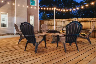 two chairs and a table on a deck with lights at Spacious King Suite, Horses, Fire Pit, Garage in Lexington