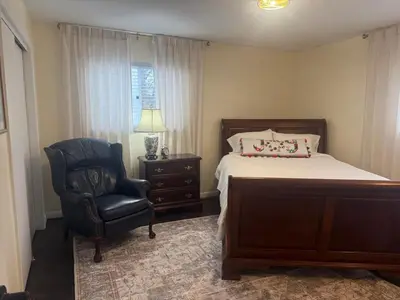 a bedroom with a bed and a chair and a lamp at 2 bedroom hot tub home near NKU in Cold Spring
