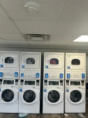 four washers and dryers are lined up in a room at Cozy 1 bedroom apartment near downtown Cincinnati in Cincinnati