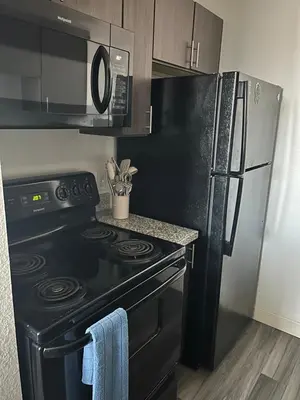 a kitchen with a black stove and a refrigerator at Cozy 1 bedroom apartment near downtown Cincinnati in Cincinnati