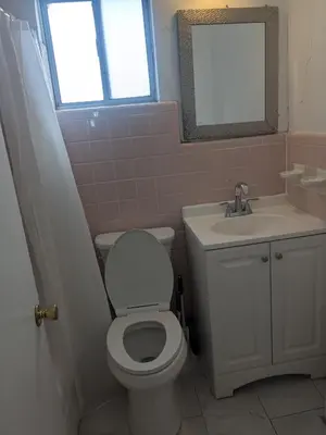 a bathroom with a toilet and a sink and a mirror at Southland Motor Lodge Hotel in Woodhaven