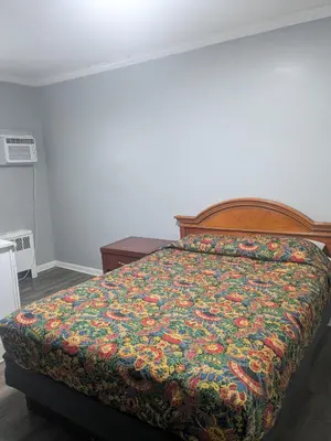 a bedroom with a bed with a colorful comforter at Southland Motor Lodge Hotel in Woodhaven