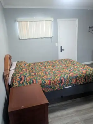 a bedroom with a bed and a table and a window at Southland Motor Lodge Hotel in Woodhaven