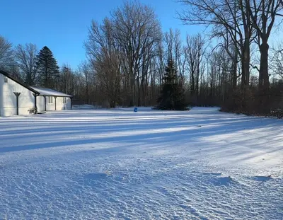 a snow covered field with a building and trees at Slice of Petersburg