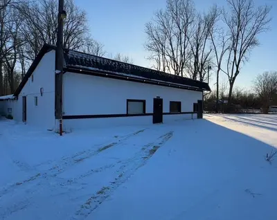 a white barn with snow on the ground at Slice of Petersburg