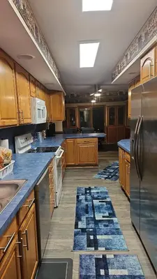 a large kitchen with wooden cabinets and stainless steel appliances at Spacious Family Retreat with ADA Ramp and ADA bathroom in Maumee