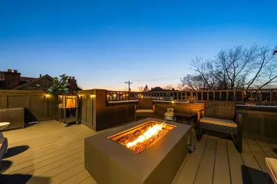 a patio with a fire pit on a deck at Rooftop Patio, Hot Tub and Games City Escape in Columbus