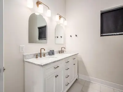 a white bathroom with a sink and a mirror at Rooftop Patio, Hot Tub and Games City Escape in Columbus