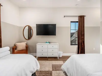 a bedroom with two beds and a flat screen tv at Rooftop Patio, Hot Tub and Games City Escape in Columbus
