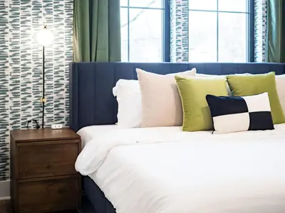 a bedroom with a bed with white and green pillows at Rooftop Patio, Hot Tub and Games City Escape in Columbus