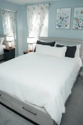 a large white bed in a bedroom with two lamps at Huber Heights Home w/Hot Tub near Rose Music/WPAFB in Dayton