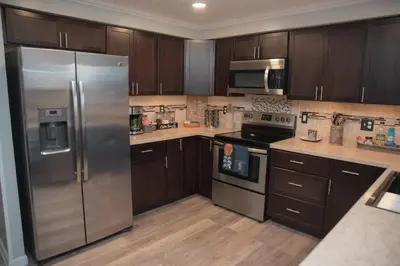 a kitchen with wooden cabinets and a stainless steel refrigerator at Huber Heights Home w/Hot Tub near Rose Music/WPAFB in Dayton