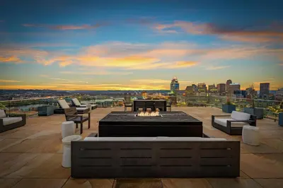 a rooftop patio with a fire pit and a city skyline at Cincinnati Vista - Rooftop, Balcony & Fireplace in Cincinnati