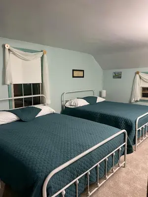 two beds in a room with blue walls at Cozy Apartment w Garage in Salem