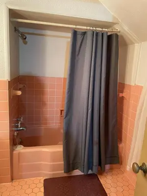 a bathroom with a shower with a blue shower curtain at Cozy Apartment w Garage in Salem