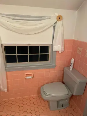 a pink bathroom with a toilet and a window at Cozy Apartment w Garage in Salem