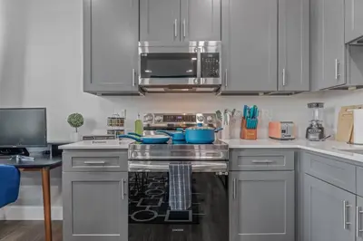 a kitchen with stainless steel appliances and white cabinets at Apt+ 2 Queens+Bunkbed+Free Parking 55