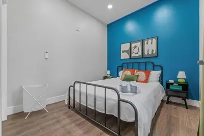 a bedroom with a bed with a blue wall at Apt+ 2 Queens+Bunkbed+Free Parking 55