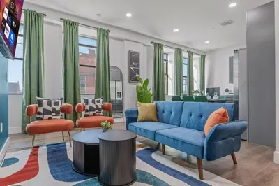 a living room with a blue couch and two chairs at Apt+ 2 Queens+Bunkbed+Free Parking 55