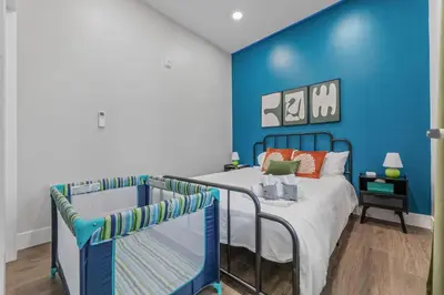 a blue bedroom with a bed and a blue wall at Apt+ 2 Queens+Bunkbed+Free Parking 55