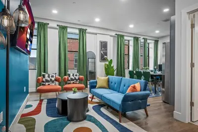 a living room with a blue couch and chairs at Apt+ 2 Queens+Bunkbed+Free Parking 55