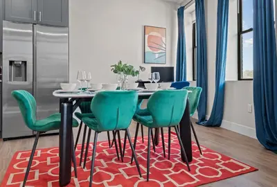a dining room with a table and green chairs at Stunning 2BR-1B Apt+Mins to Zoo& D/T+HD Projector in Cleveland