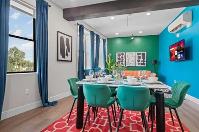 a dining room with a table and green chairs at Stunning 2BR-1B Apt+Mins to Zoo& D/T+HD Projector in Cleveland