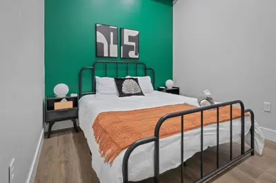 a bedroom with a bed with a green wall at Stunning 2BR-1B Apt+Mins to Zoo& D/T+HD Projector in Cleveland